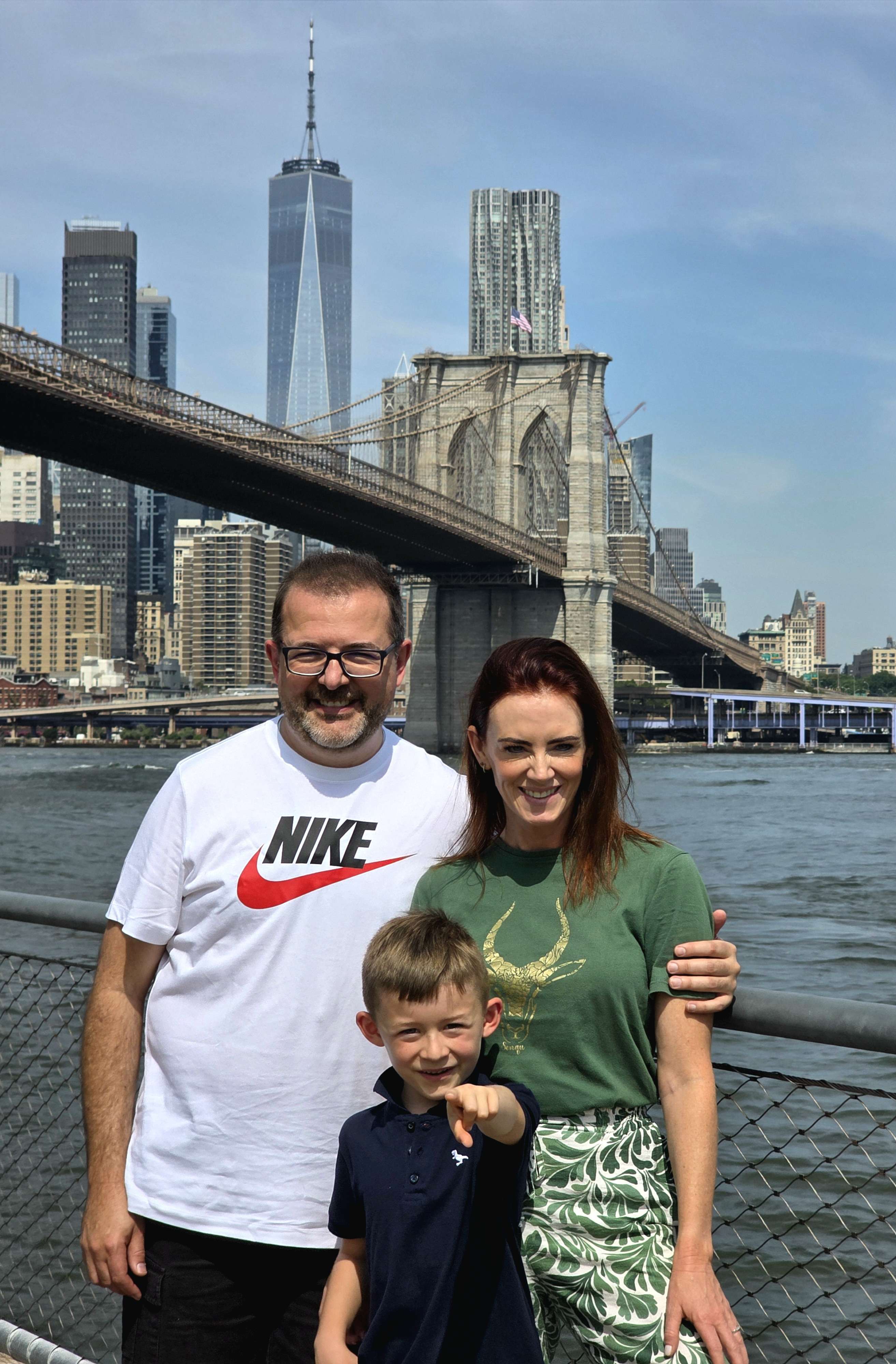 The family at the waterfront with the Brooklyn Bridge and Lower Manhattan behind them.