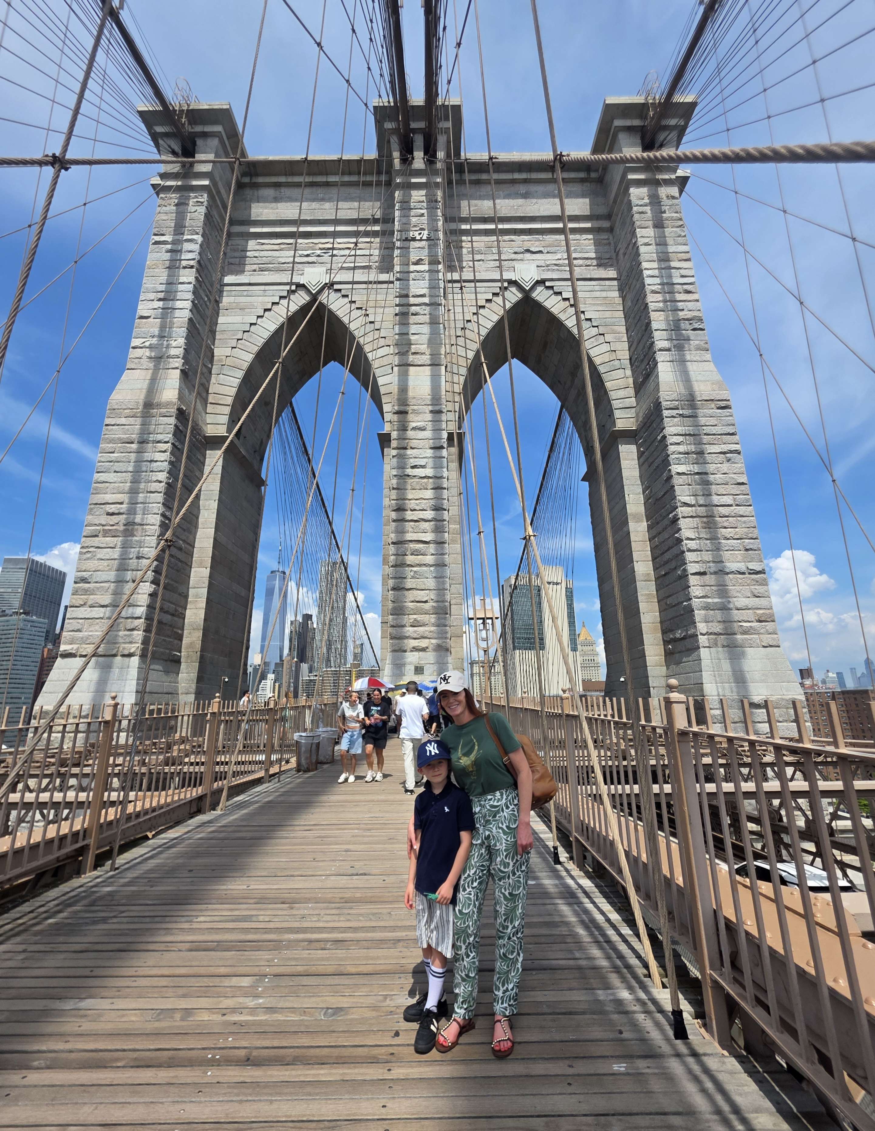 Looking up at the Brooklyn Bridge tower and cables from the wooden walkway.